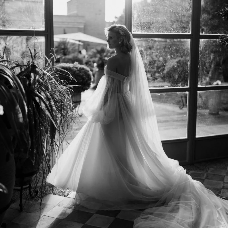 Mariée en robe de tulle devant une verrière, mariage à Marrakech